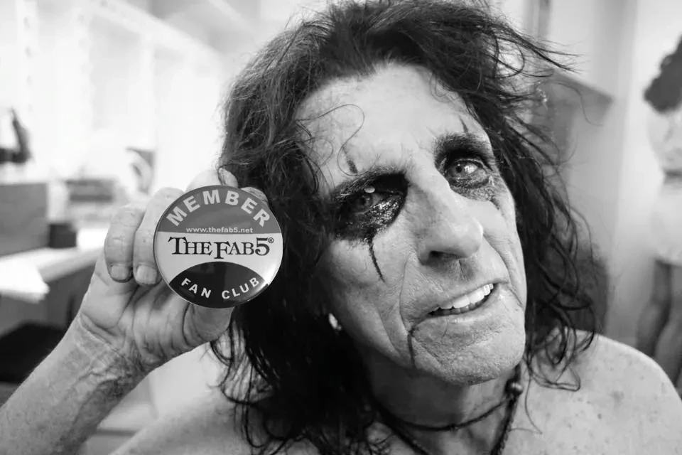 Alice Cooper holding a Fab 5 Fan Club member badge