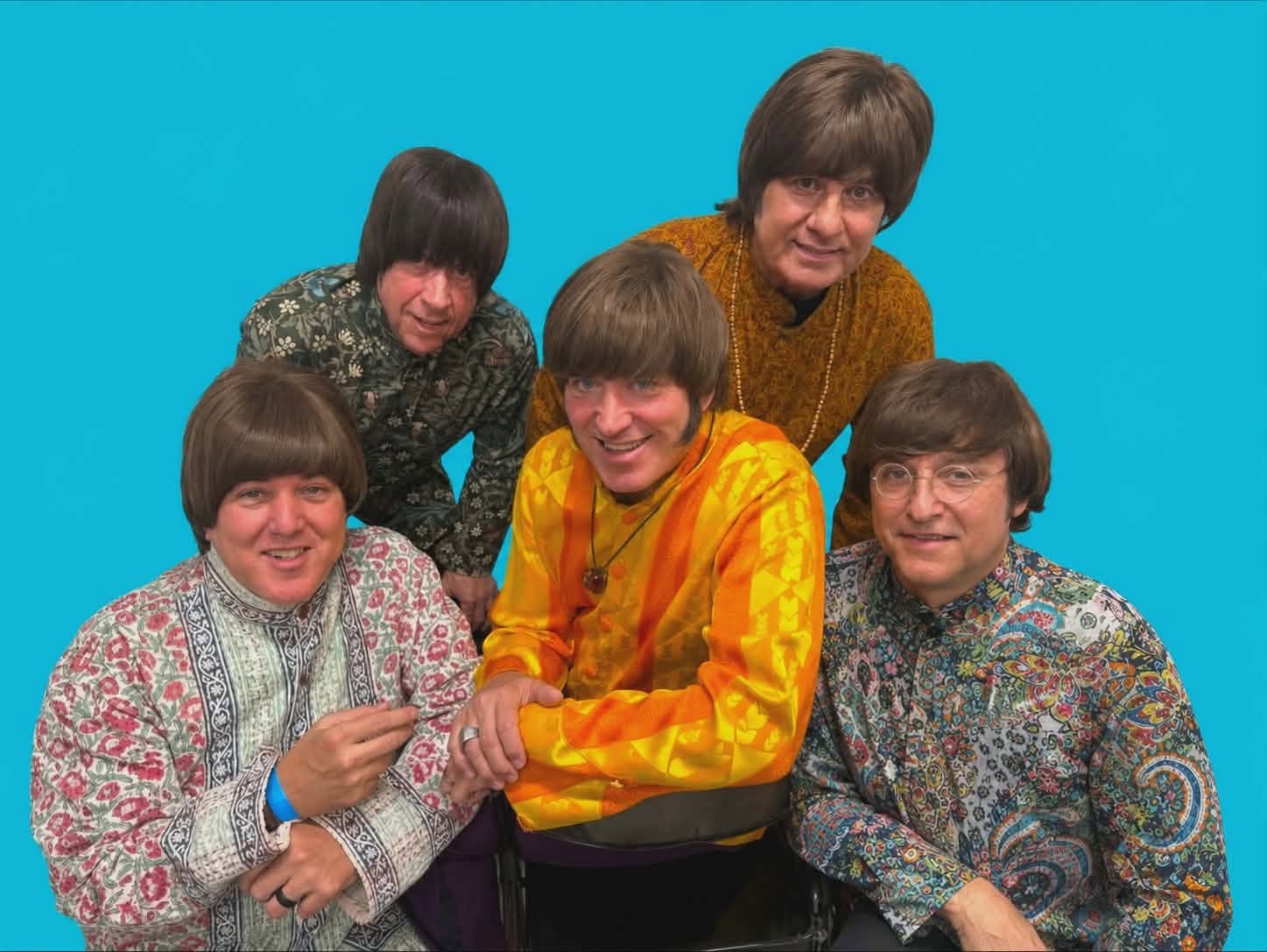 The Fab 5 in psychedelic floral shirts against turquoise background